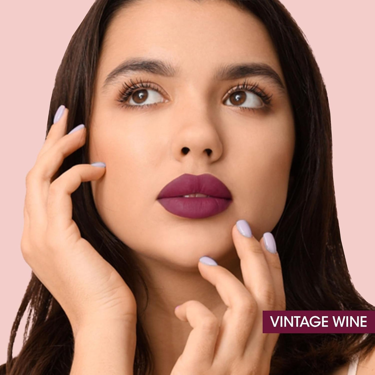 A model gracefully applying the Vintage Wine Liquid Lipstick with its precision wand.