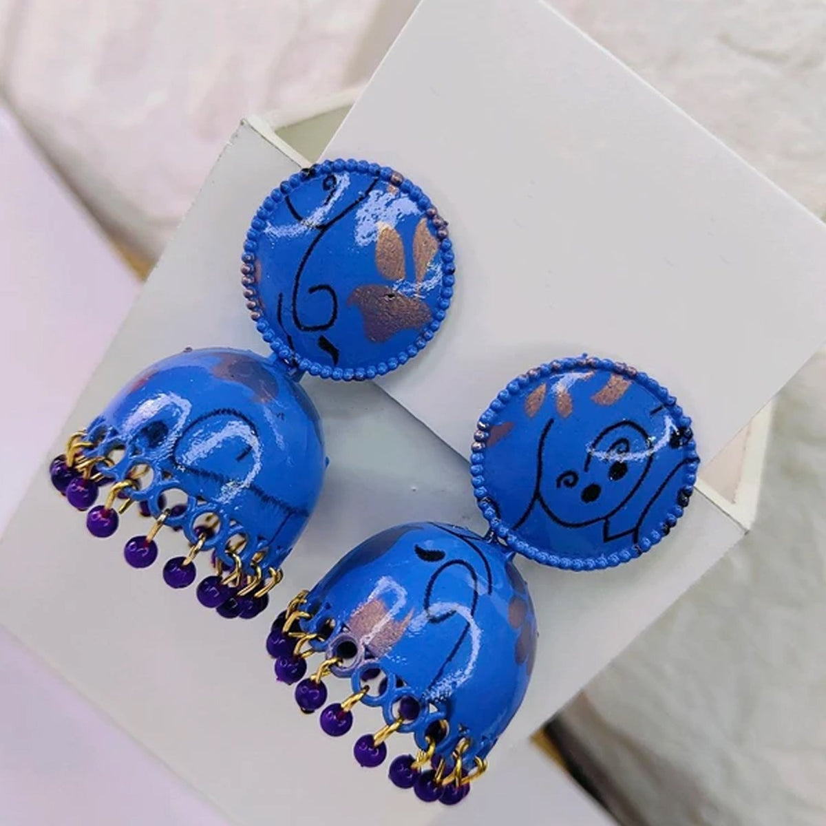 Vibrant blue Jhumka Earrings with intricate golden patterns, suitable for a pop of color in ethnic ensembles.